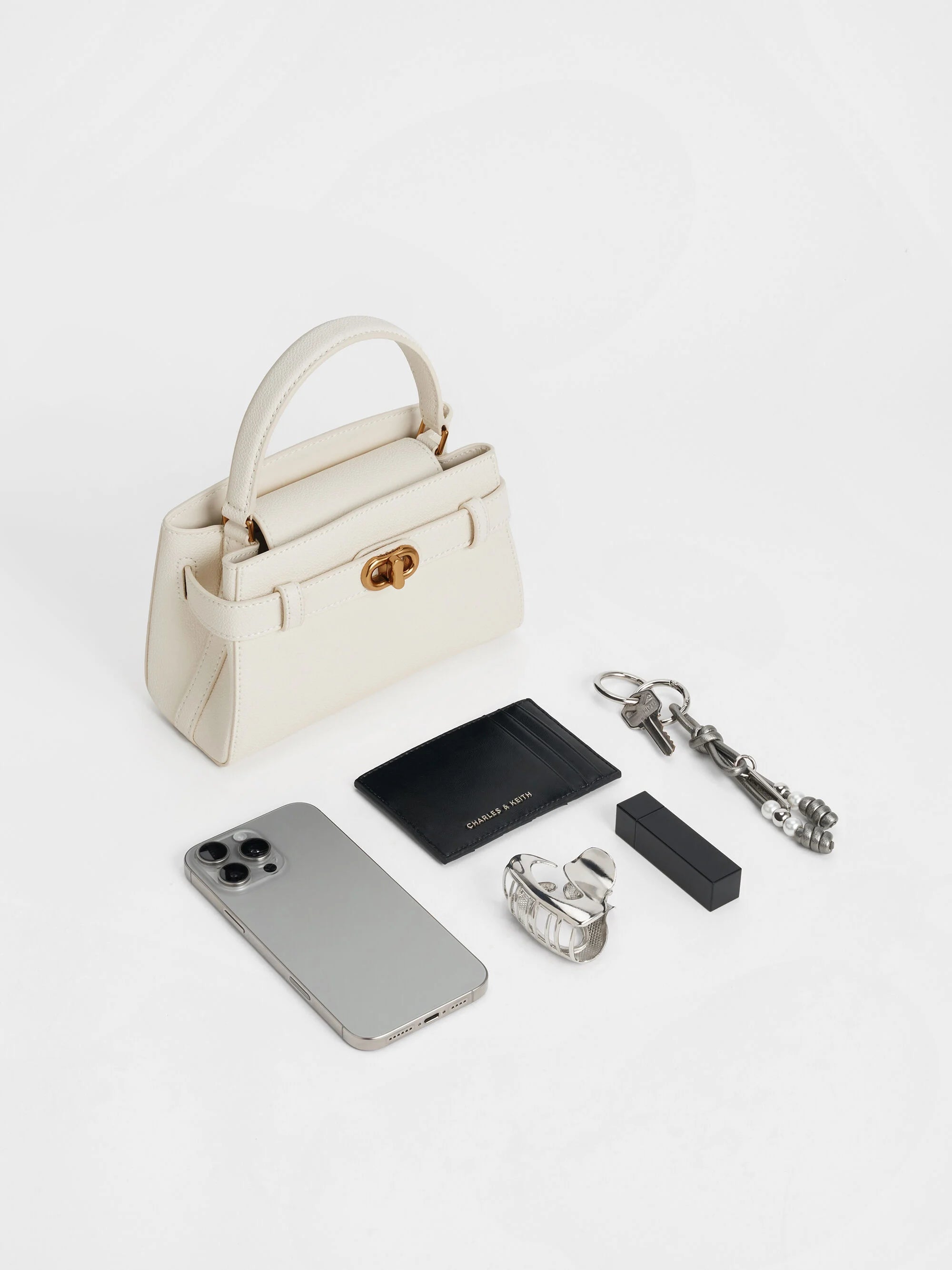 Aubrielle metallic-buckle top handle bag in cream