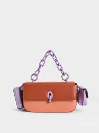 Wren Acrylic Handle Phone Pouch in a brick or orange color.